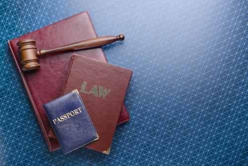 דרכון כחול מונח על ספרים לעריכת דין שמונחים על שולחן