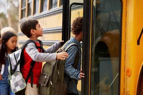 תקריב על מגוון ילדים שעולים על האוטובוס הצהוב