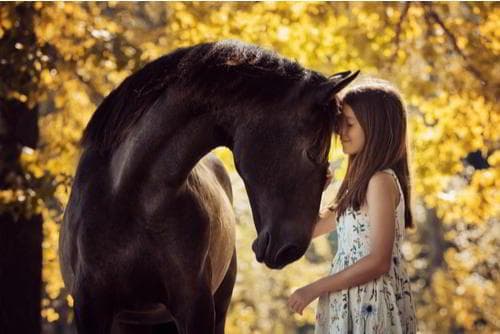 ילדה עם הסוס שלה ברכיבה טיפולית